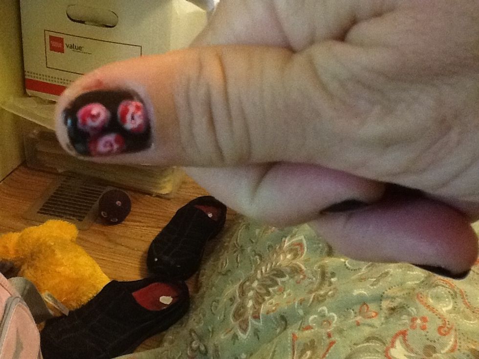 Jessica used a fine paintbrush for her detail. All I had was a pin. I dabbed a pin tip (pointy end) into red polish and made a tiny "U" shape in the middle and the little rough half circles.