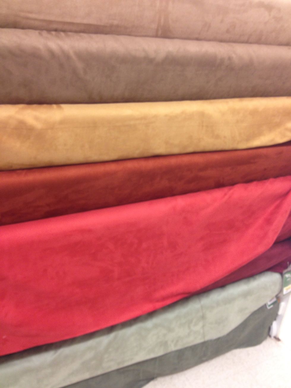 Jo-Anns fabrics has a huge selection of home decor fabrics. Look for the ones on the roll like in the photo. These are like a "microfiber" suede / come in many colors. 3 yards for one table.