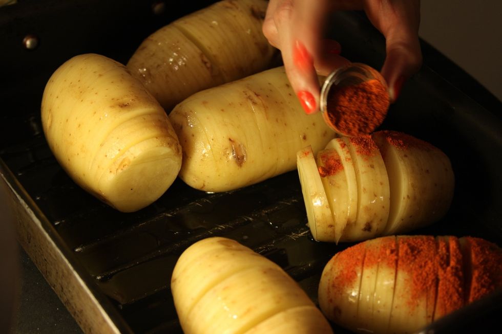 Jogue por cima das diferentes batatas a paprika, a pimenta siria e o alecrim.