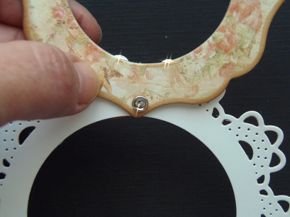 Join doily and chipboard frame together using a small brad.