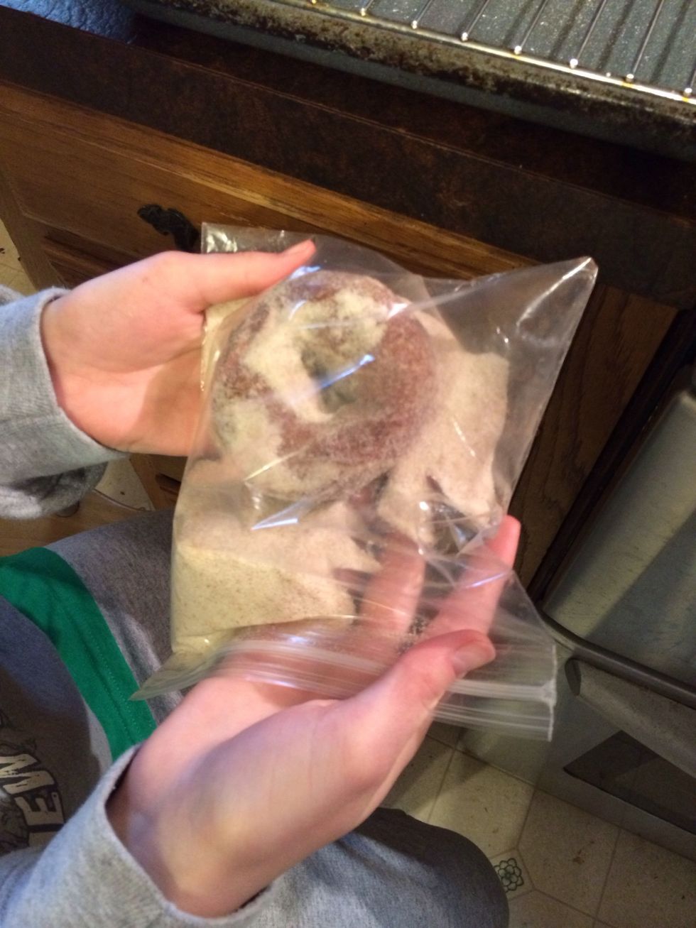 JoJo put doughnut in the bag coating well.