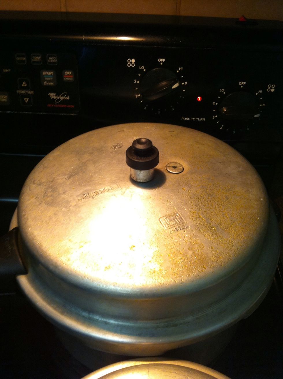 Just put the lid and get the temperature to medium and wait for 3 whistles. Ensure to remove the cooker from heat after its done to make sure the bottom doesn't burn.