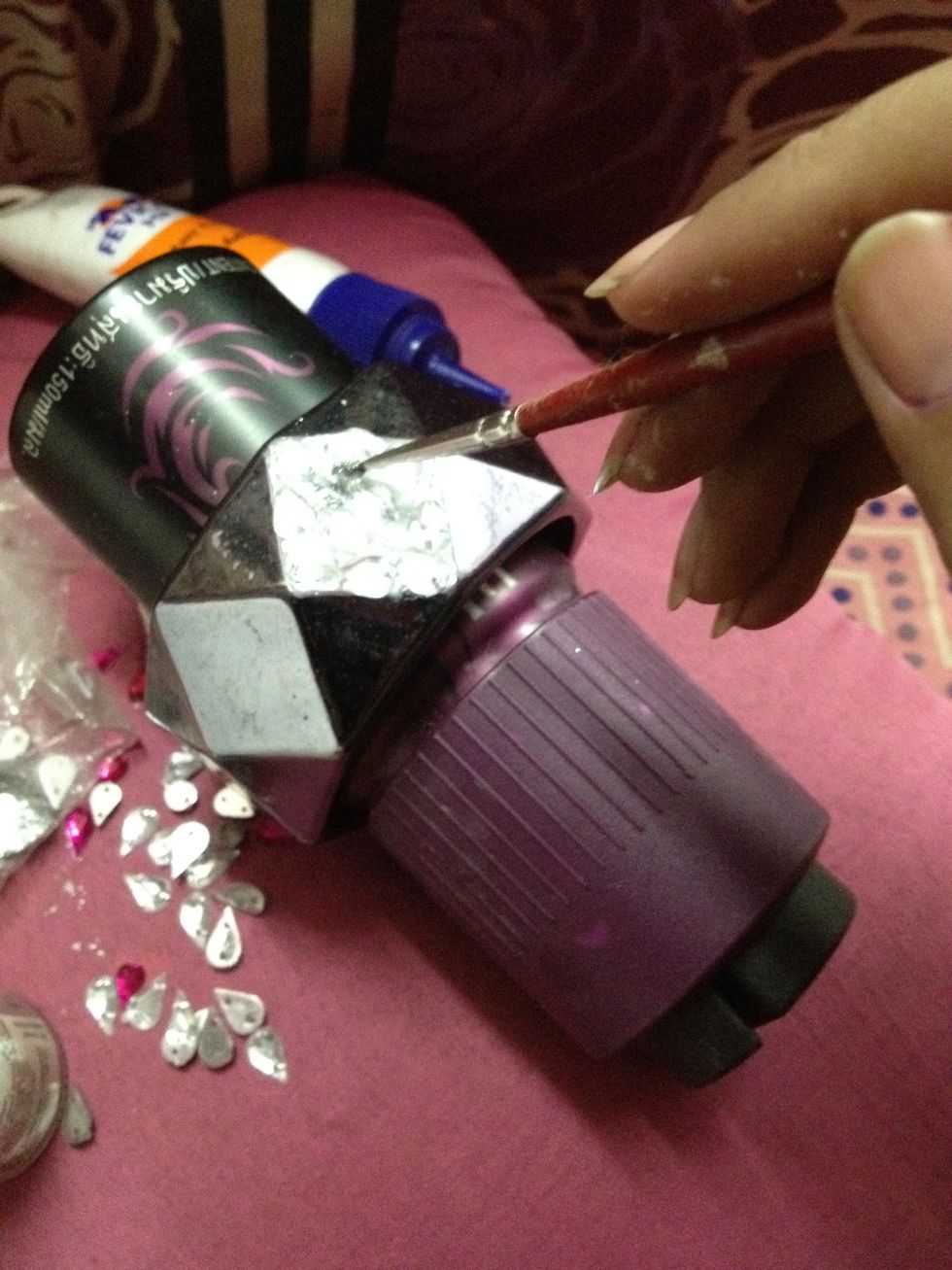 Just tap  it on the wet glue in between the stones..
