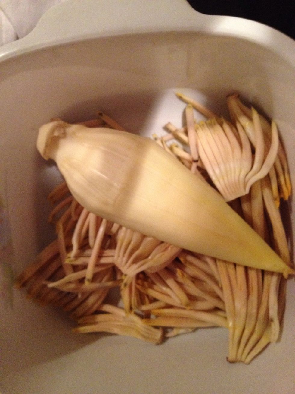 Keep peeling until you reach the white yellow flower heart. Put in a bowl, add cold water, lemon juice to avoid discolouring of the heart.