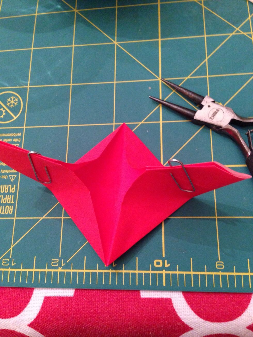 Keep pushing the edges upward to meet. This will make the center area flat. Now press the top and bottom corners together and flatten.