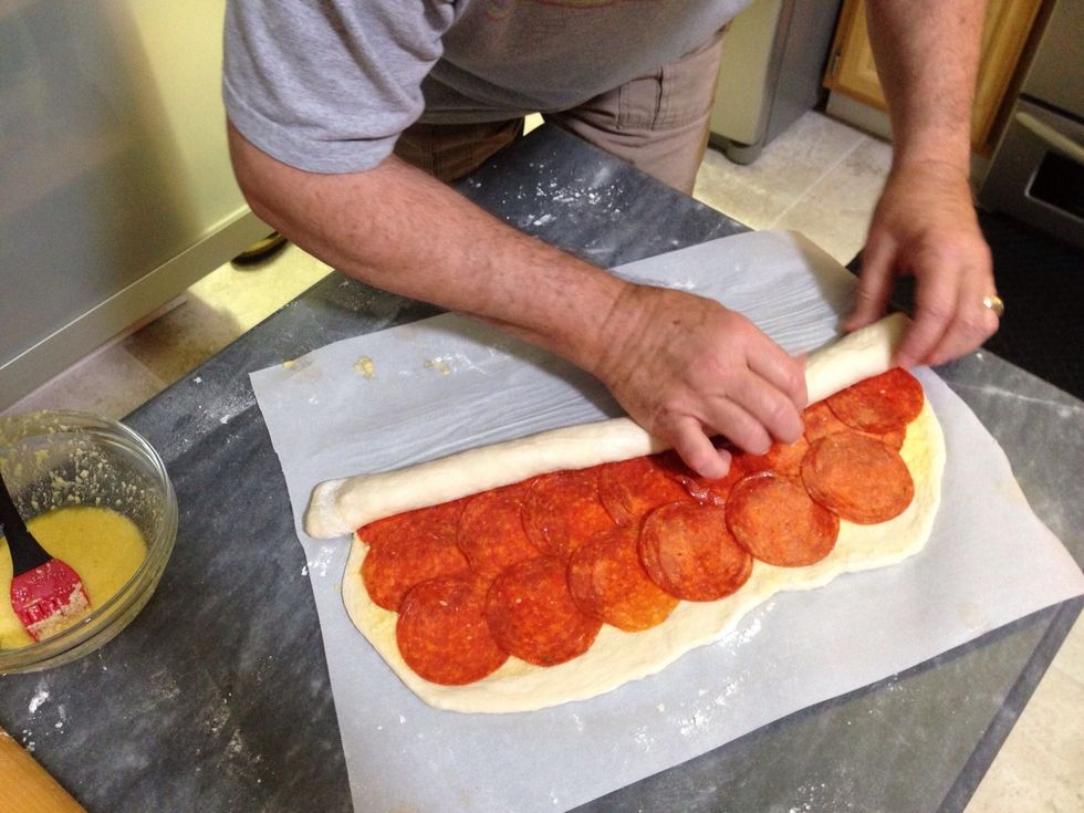 Keep rolling keeping it even all the way across and don't roll it very tightly anymore. Just roll it easily so you don't compress the dough.