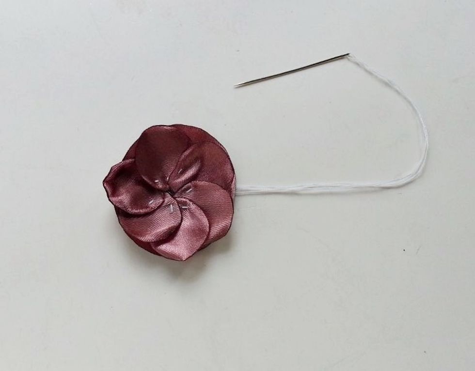 Keep stitching the petals around the edge of the base piece until you\u2019ve covered the entire edge.