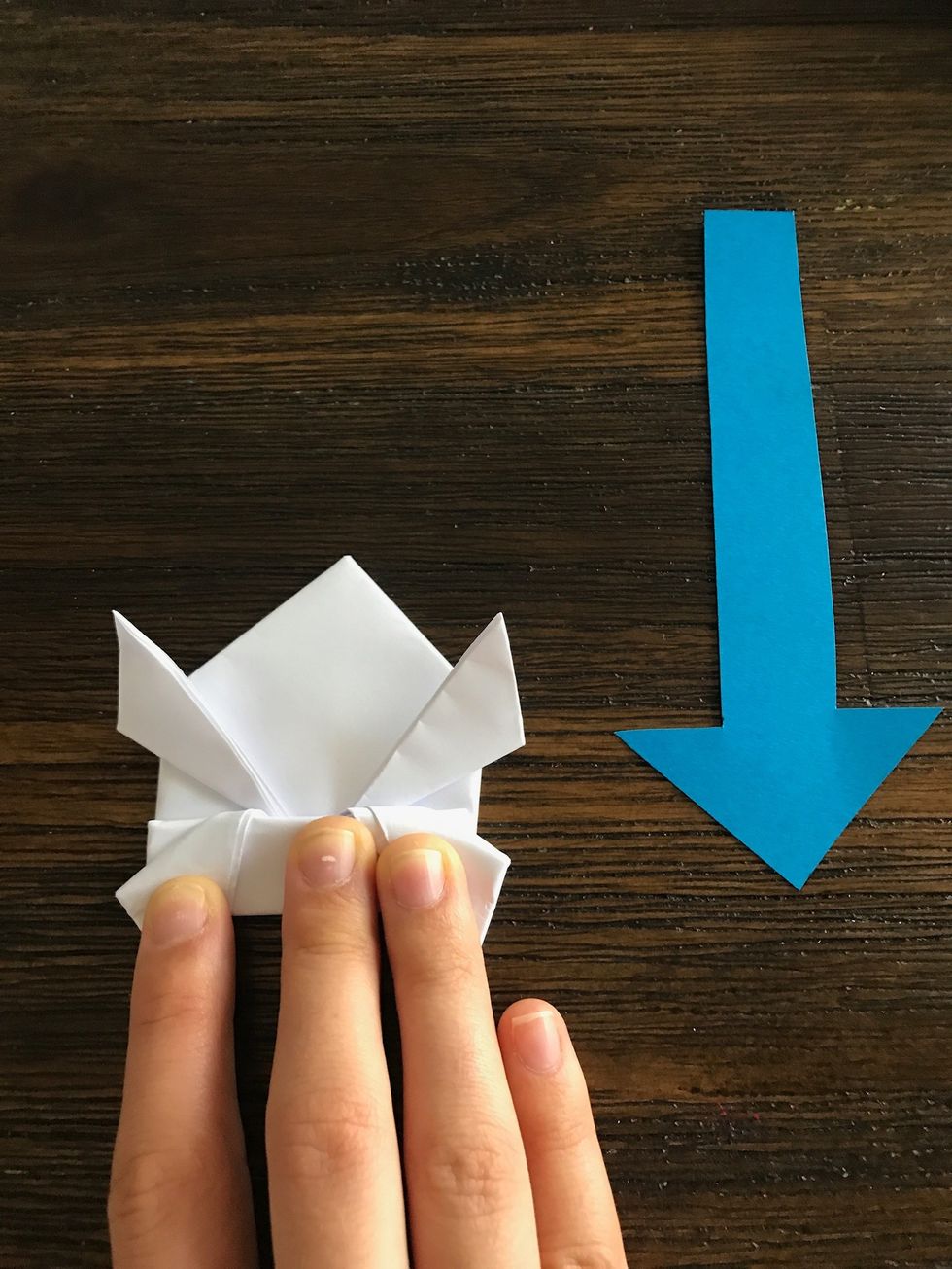 Keep the from folded in half while folding the bottom legs of the frog down, kind of like an accordion.