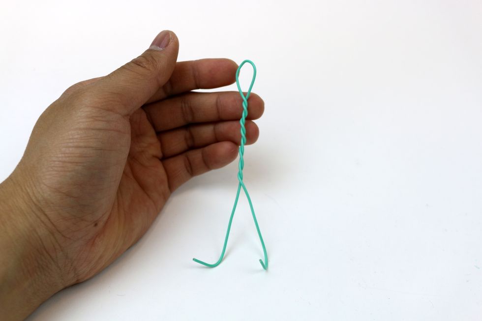 Keep twisting the two ends together to form an upper body. Leave the two ends with about 2 inches untwisted. Spread the two ends to form legs.