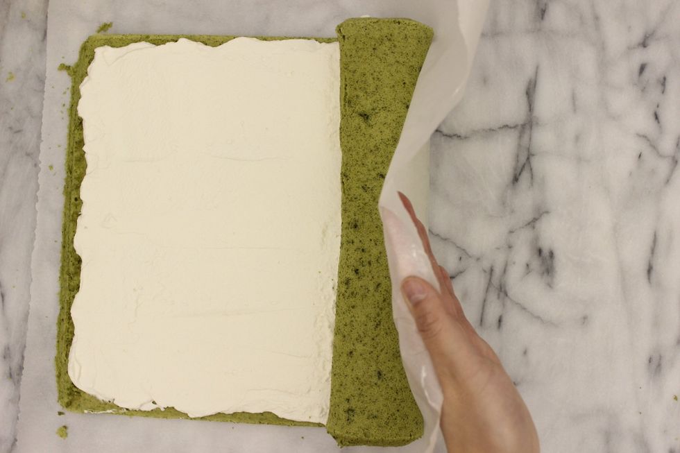 Keep using the parchment paper to help roll the cake.