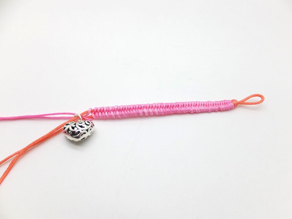 Keep working in the same pattern (over-under-pull, over-under-pull) until you reach the half length of your wrist. Then string a heart-shaped charm pendant.