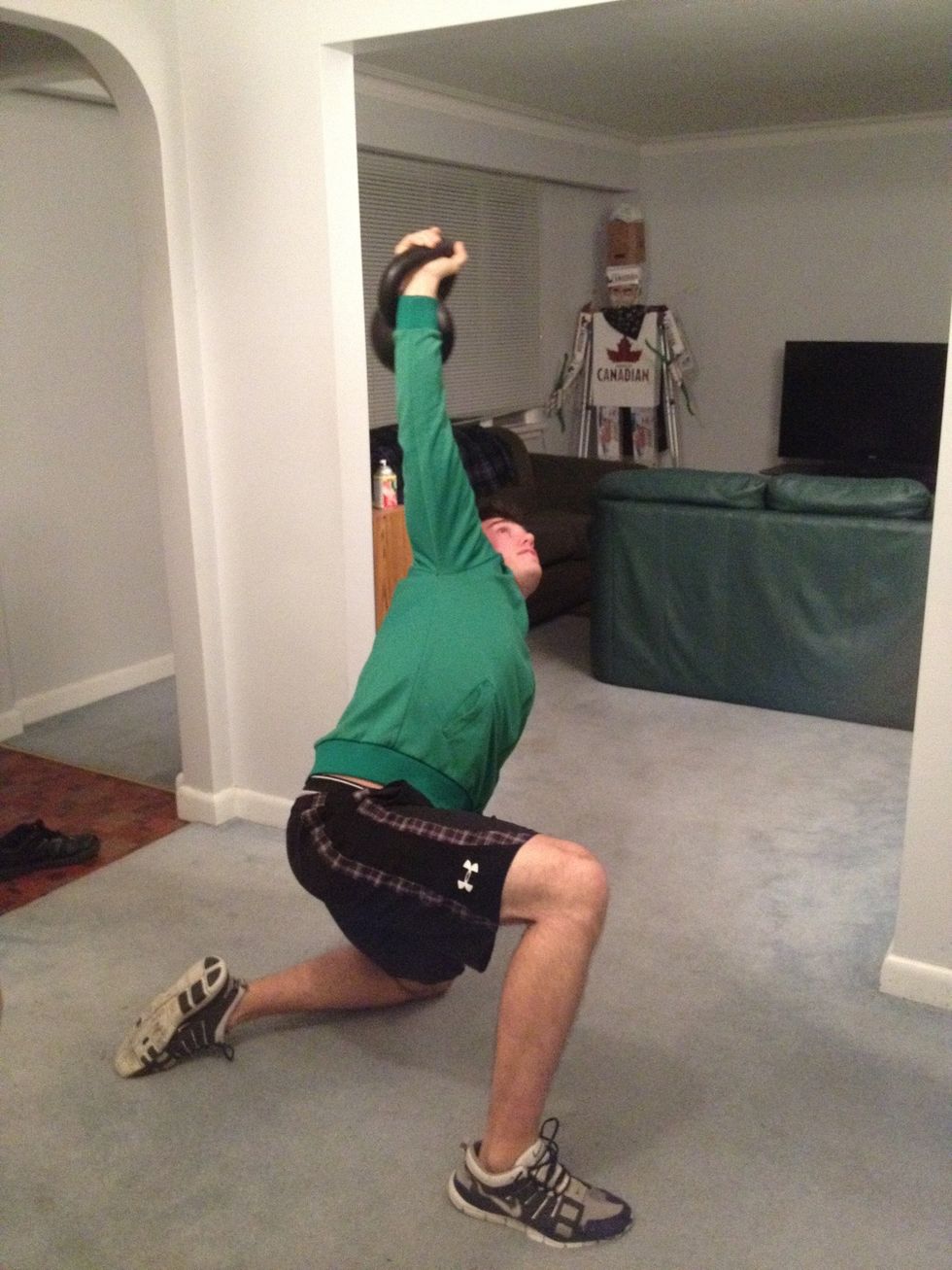 Keeping the kettlebell high, slide knee back