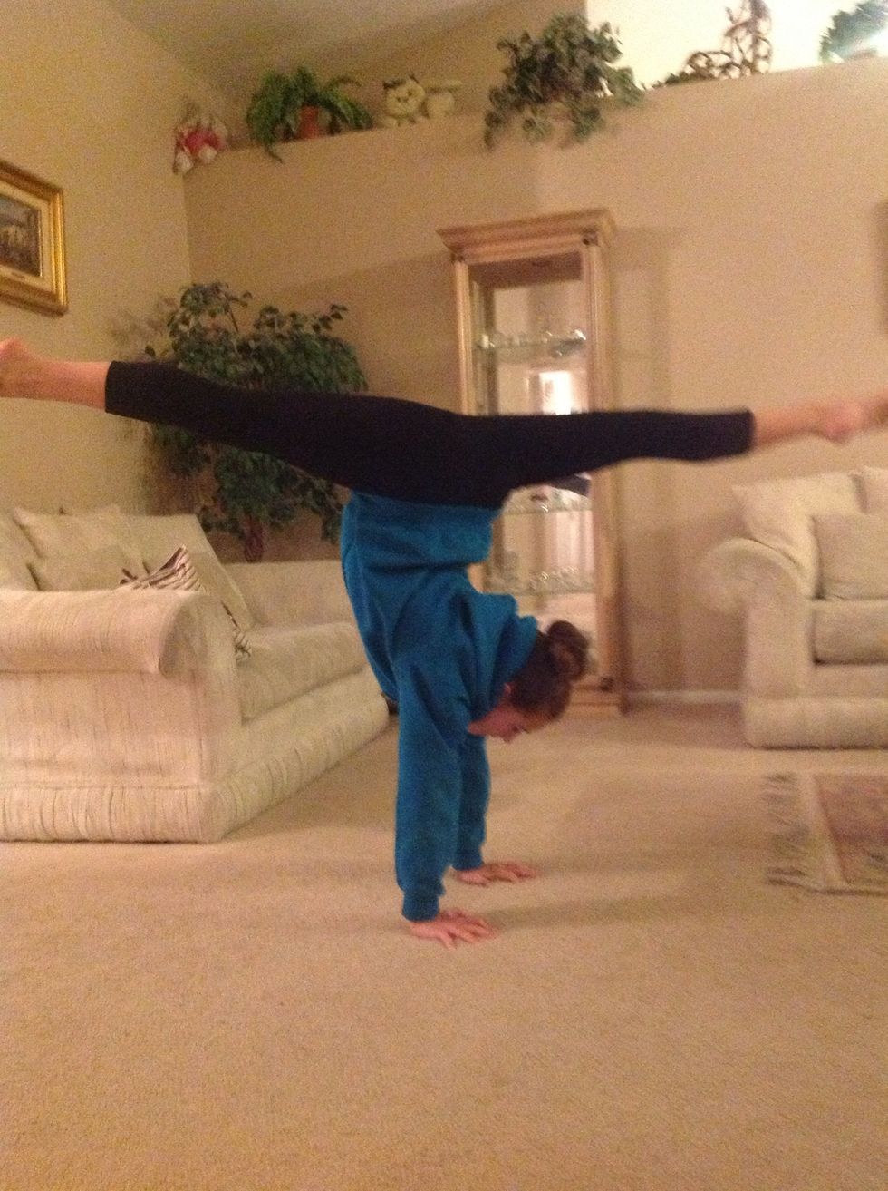 Kick your legs into an open split position with hands still firmly on the ground.
