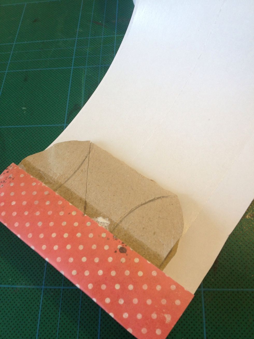 Kl\u00e4 pappret med sj\u00e4lvh\u00e4ftande tejp och f\u00e4st p\u00e5 kartongen.