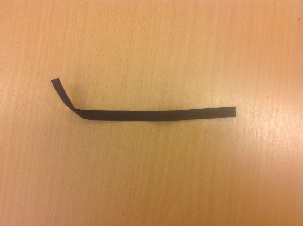 Klipp av en bit svart bomullsband, ca 15 cm.