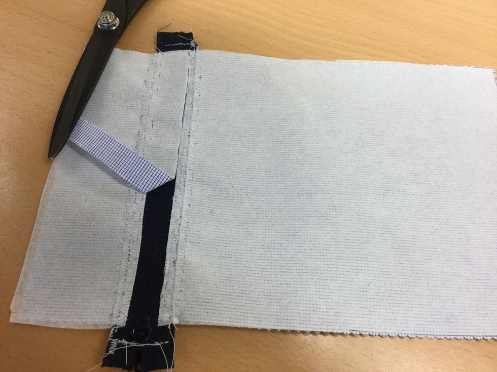 Klipp bort tyget mellan s\u00f6mmarna p\u00e5 avigsidan.