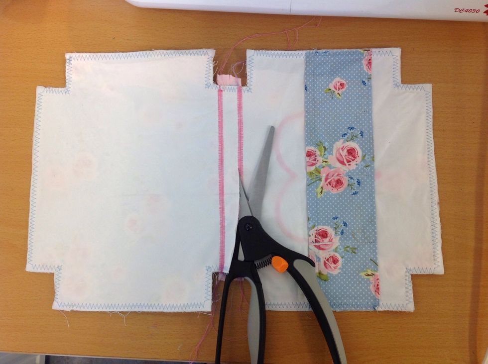 Klipp bort tyget under dragkedjan p\u00e5 avigsidan.