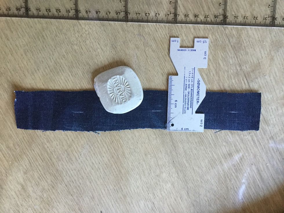 Klipp ett jeanstyg ca. 4 * 25 cm. S\u00e4tt sm\u00e5 m\u00e4rke med krita ca. 2 cm inne.