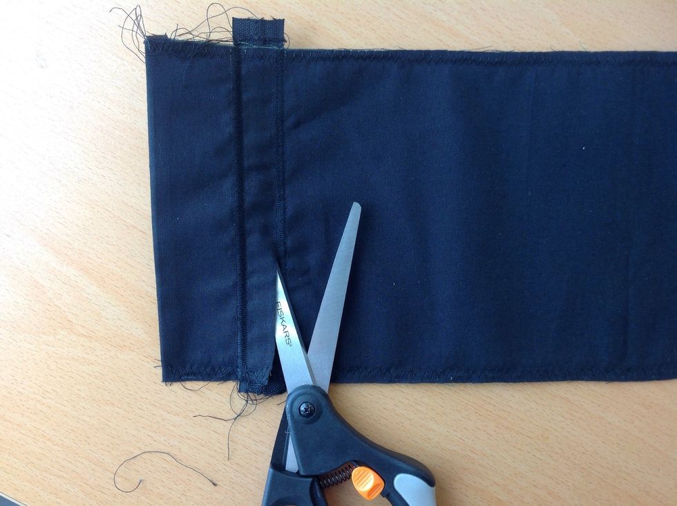 Klipp f\u00f6rsiktigt bort tyget bakom dragkedjan. Vinkla saxen s\u00e5 g\u00e5r det l\u00e4ttare.