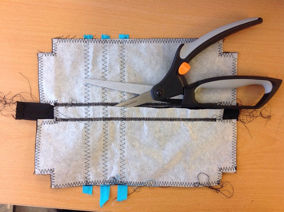 Klipp f\u00f6rsiktigt bort tyget under dragkedjan p\u00e5 avigsidan (baksidan).