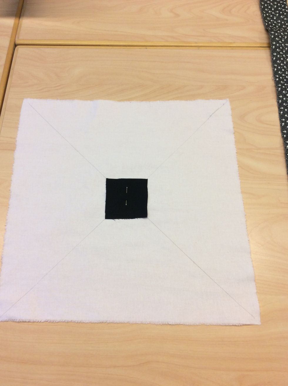 Klipp nu ut en kvadrat p\u00e5 6x6cm och n\u00e5la fast den mitt p\u00e5 tyget.