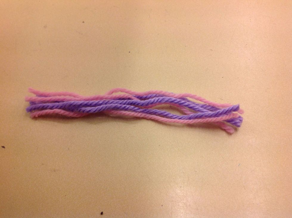 Klipp till 6 tr\u00e5dar garn 20 cm l\u00e5nga.