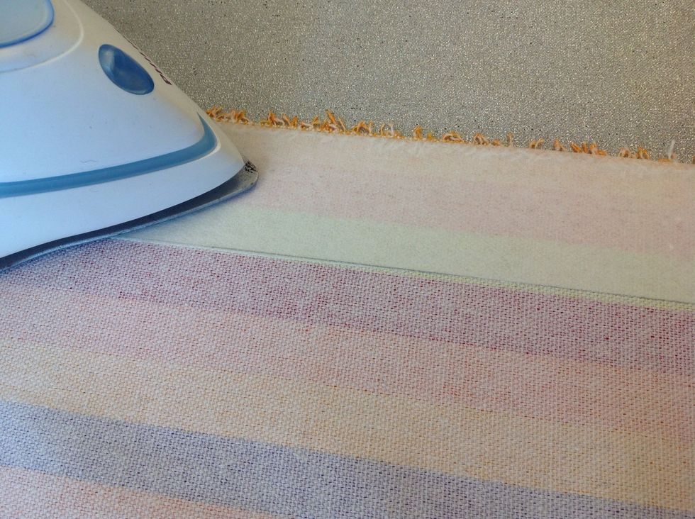 Klipp till en bit f\u00f6rst\u00e4rkningstyg som \u00e4r lika l\u00e5ng som din v\u00e4skdel och 5 cm bred. Stryk fast den p\u00e5 ovankantens avigsida. D\u00e4r ska \u00f6ljetterna sitta sen. Till en liten v\u00e4ska r\u00e4cker det 4 cm bred.