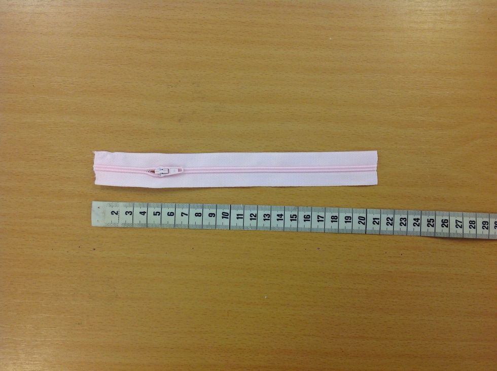 Klipp till en dragkedja 20 cm l\u00e5ng. Det ska finnas en l\u00f6pare p\u00e5 din bit.