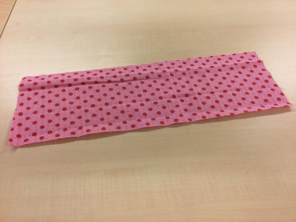 Klipp till en tygbit i m\u00e5tten 12x40 cm. Det finns en mall att rita av om man vill.