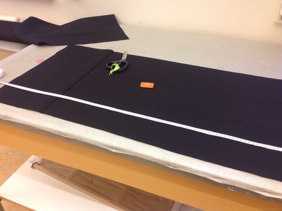 Klipp tyget efter dina markeringar, klipp igenom b\u00e5da tyglagren. Vik ut tyget till en l\u00e5ng remsa, m\u00e4t och markera 100cm fr\u00e5n ena kortsidan. Klipp.