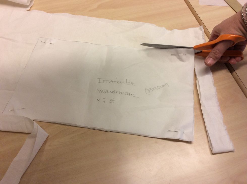 Klipp ut b\u00e5da lagerna tyg med en tygsax.