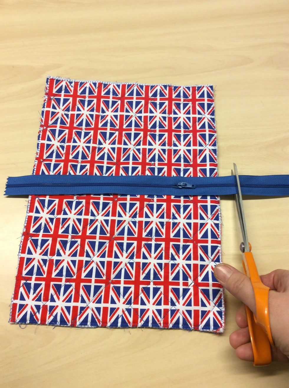 Klipp ut en dragkedja i passande f\u00e4rg n\u00e5gra centimeter l\u00e4ngre \u00e4n tyget.