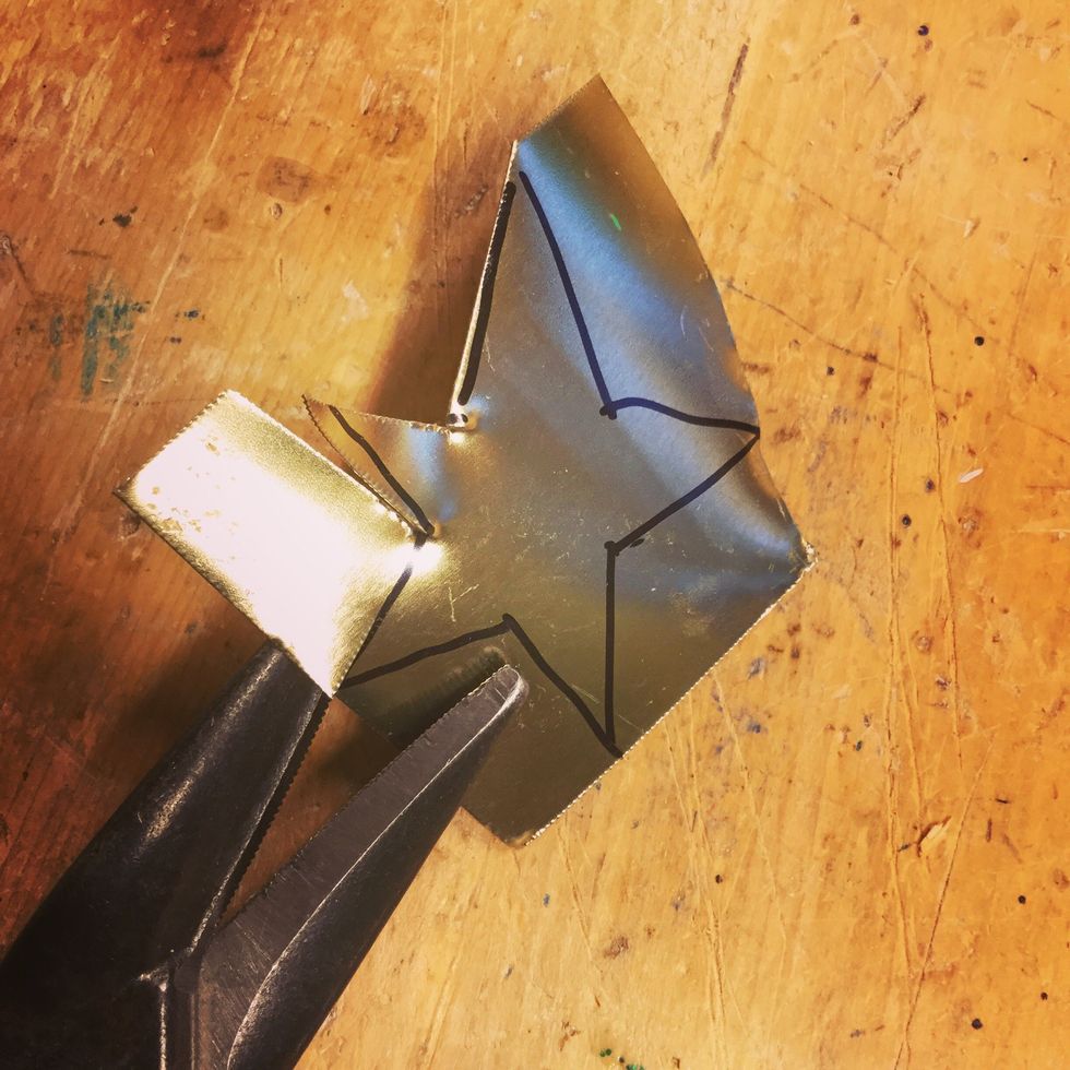 Klipp ut stj\u00e4rnan genom att klippa ena sidan in mot mitten. G\u00f6r sedan ett nytt klipp fr\u00e5n andra h\u00e5llet.