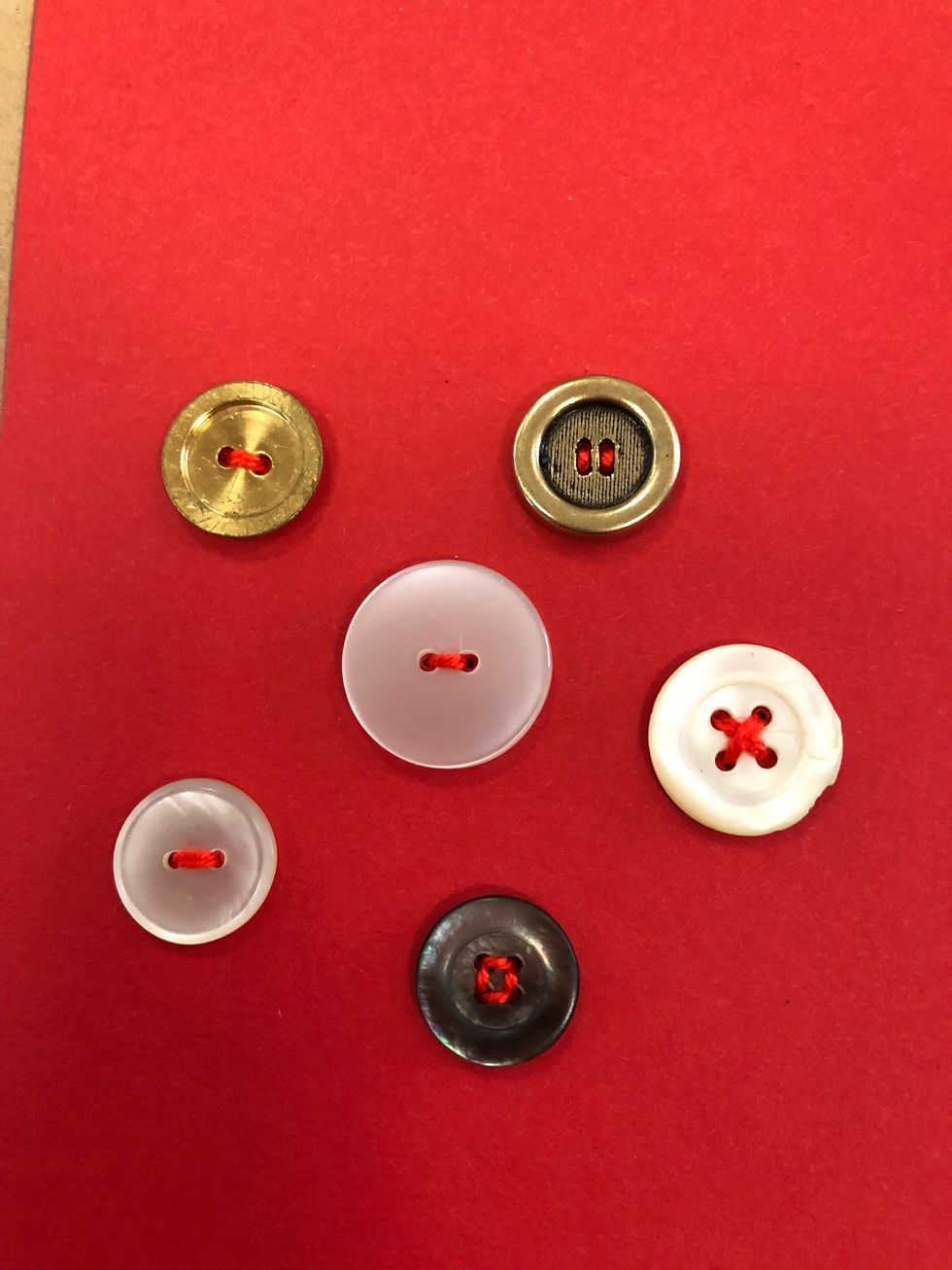 Knappar med fyra h\u00e5l g\u00e5r att sy fast med olika m\u00f6nster.