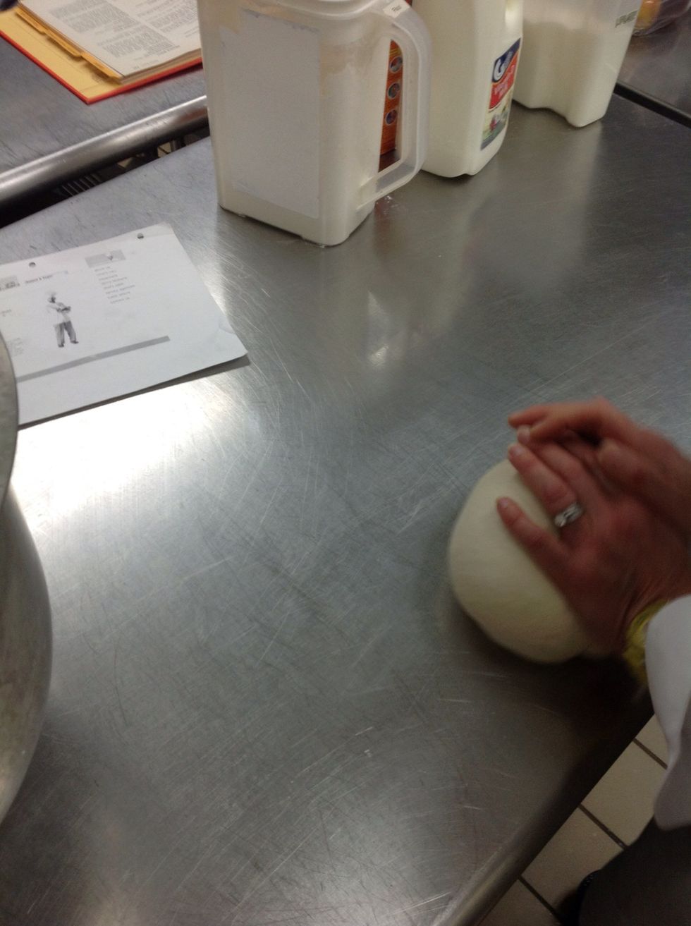 Knead bread dough into a ball.