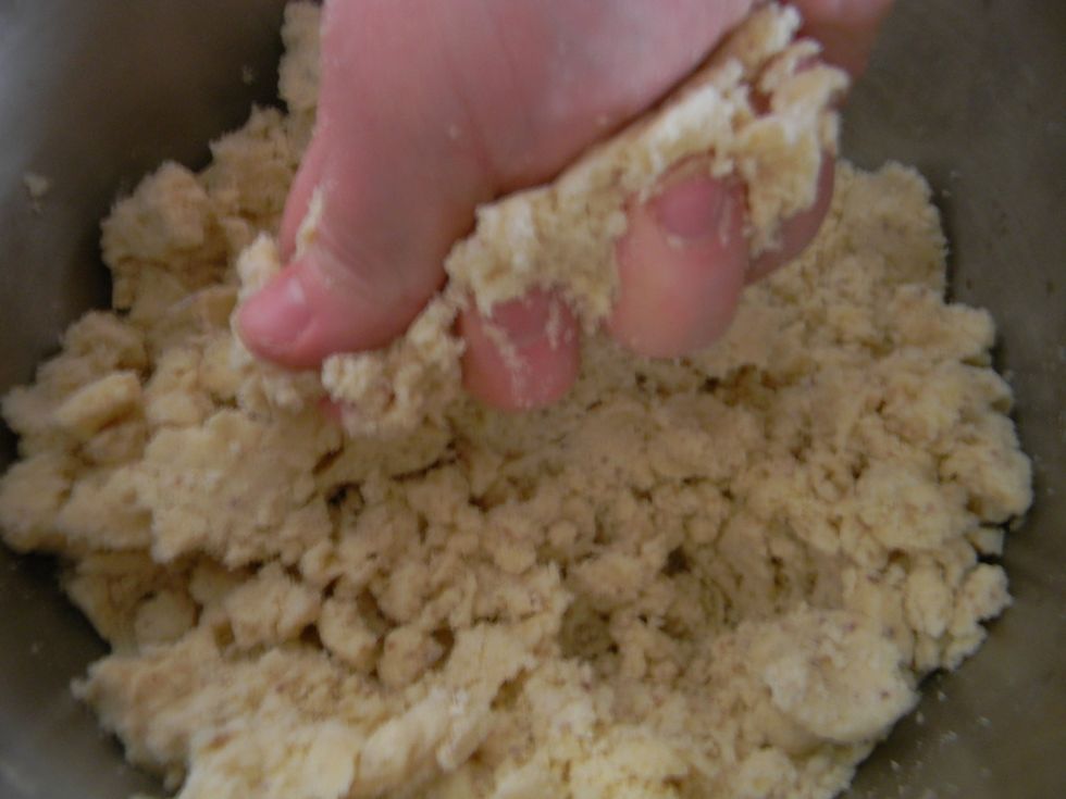Knead everything together until you see no more flour clouds. If the dough won't hold together at all you might have added too much flour. Just mix in a tbsp of milk or two to make up for it.