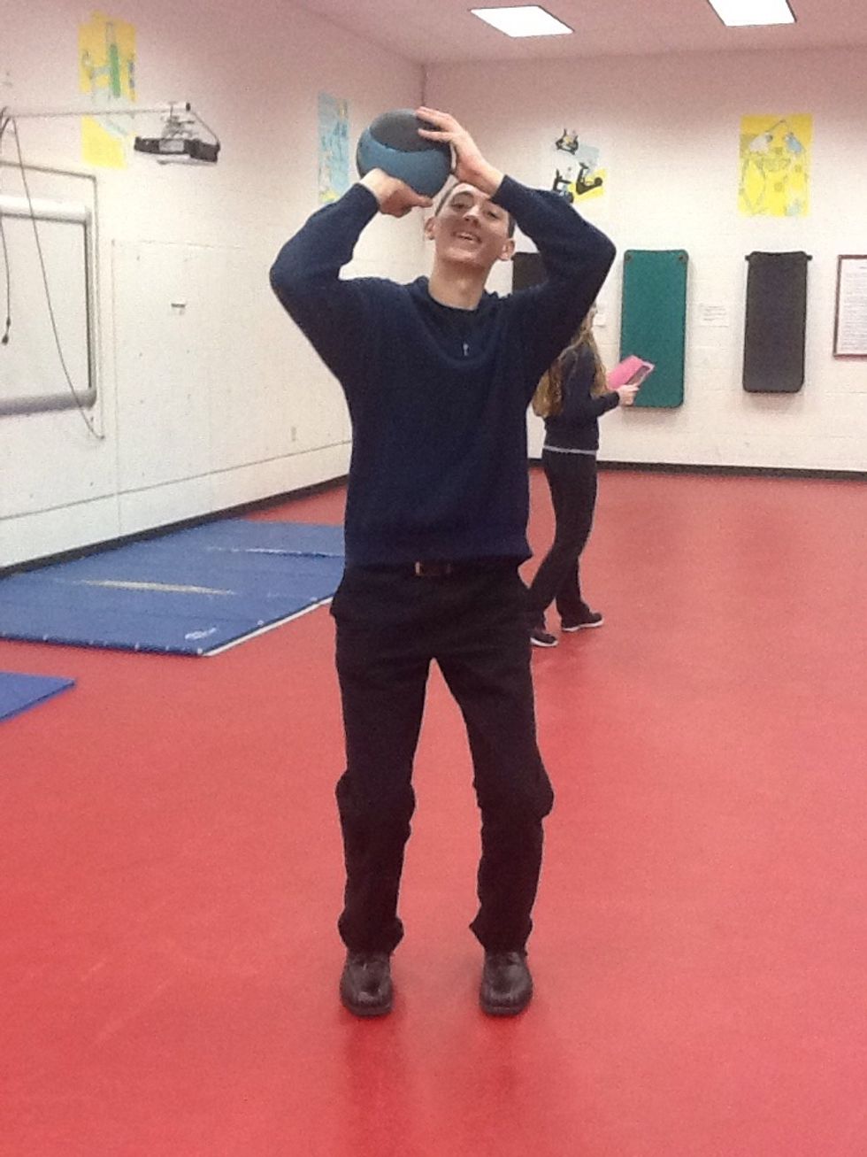 Knee flexion; elbow flexion; right wrist extension, left wrist neutral; quadriceps, deltoids, are used, feet in neutral position; gastrocnemius involved. Quads are going through eccentric contraction