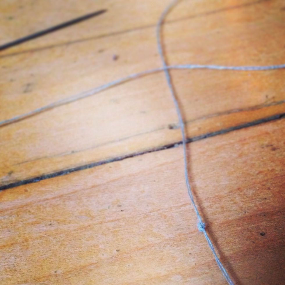Knot the bottom of the strand. Add a cotton ball then create another knot about an inch above the cotton ball.