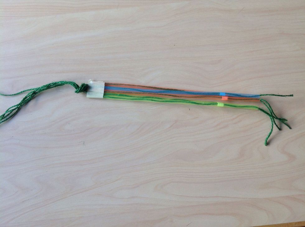 Knyt en knut s\u00e5 det bara sticker ut lite ur andra \u00e4nden p\u00e5 sugr\u00f6ret. S\u00e4tt lite tejp i \u00e4nden f\u00f6r att f\u00e4sta ihop sugr\u00f6ren platt.