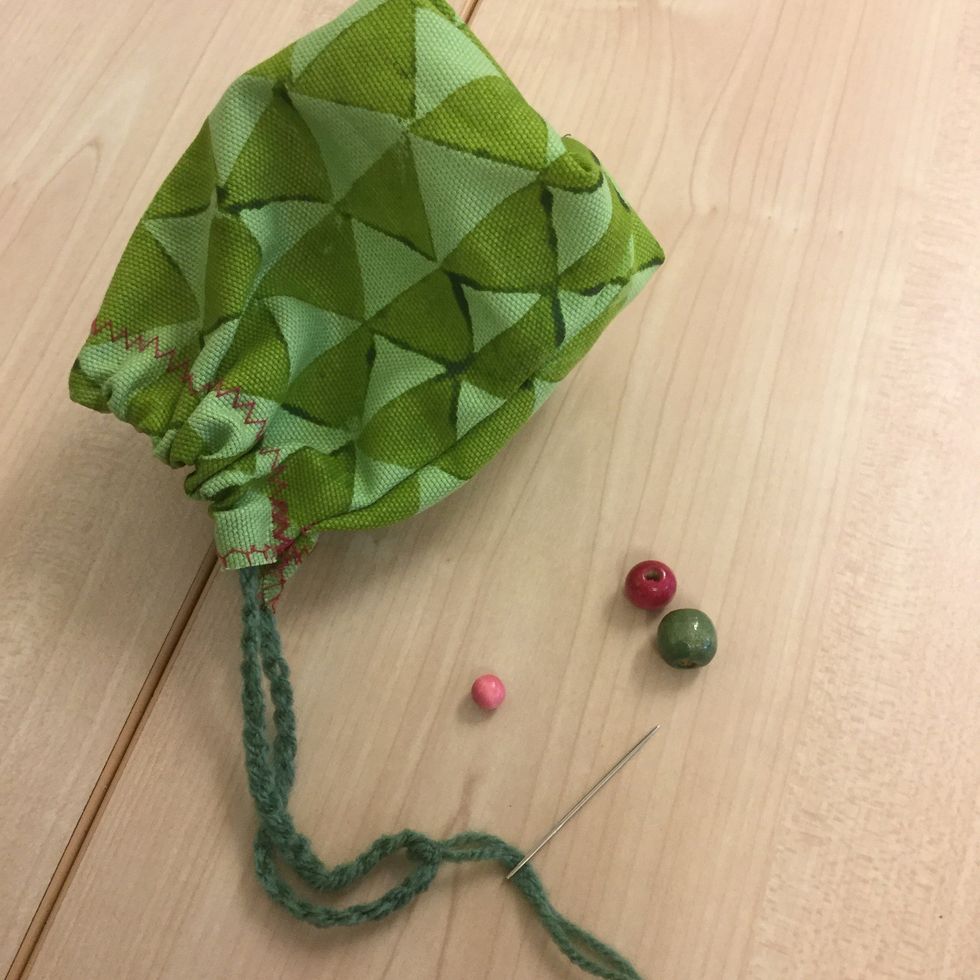 Knyt ihop \u00e4ndarna p\u00e5 snodden med minst en dubbelknut. Tr\u00e4 p\u00e5 en broderin\u00e5l med spets, om du vill tr\u00e4 p\u00e5 p\u00e4rlor.