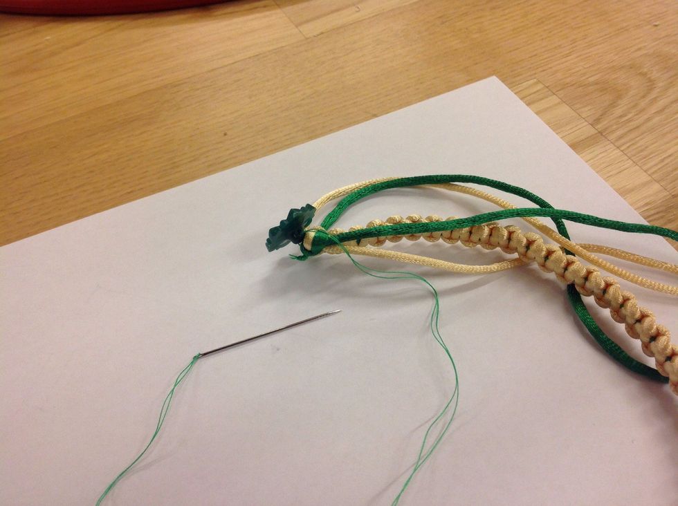 Knyt n\u00e5gra knutar i slutet och sy sedan p\u00e5 en passande knapp. Gl\u00f6m inte testa om knappen funkar i \u00f6glan i andra \u00e4nden p\u00e5 armbandet.