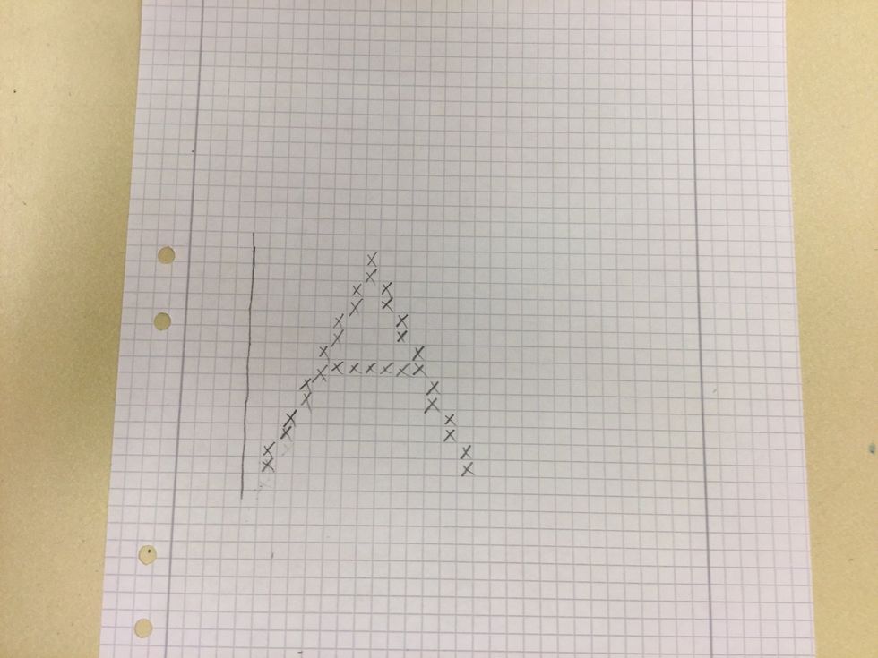 Korsstygnsbroderi. Rita en bokstav p\u00e5 ett rutat papper 15x 15 rutor.