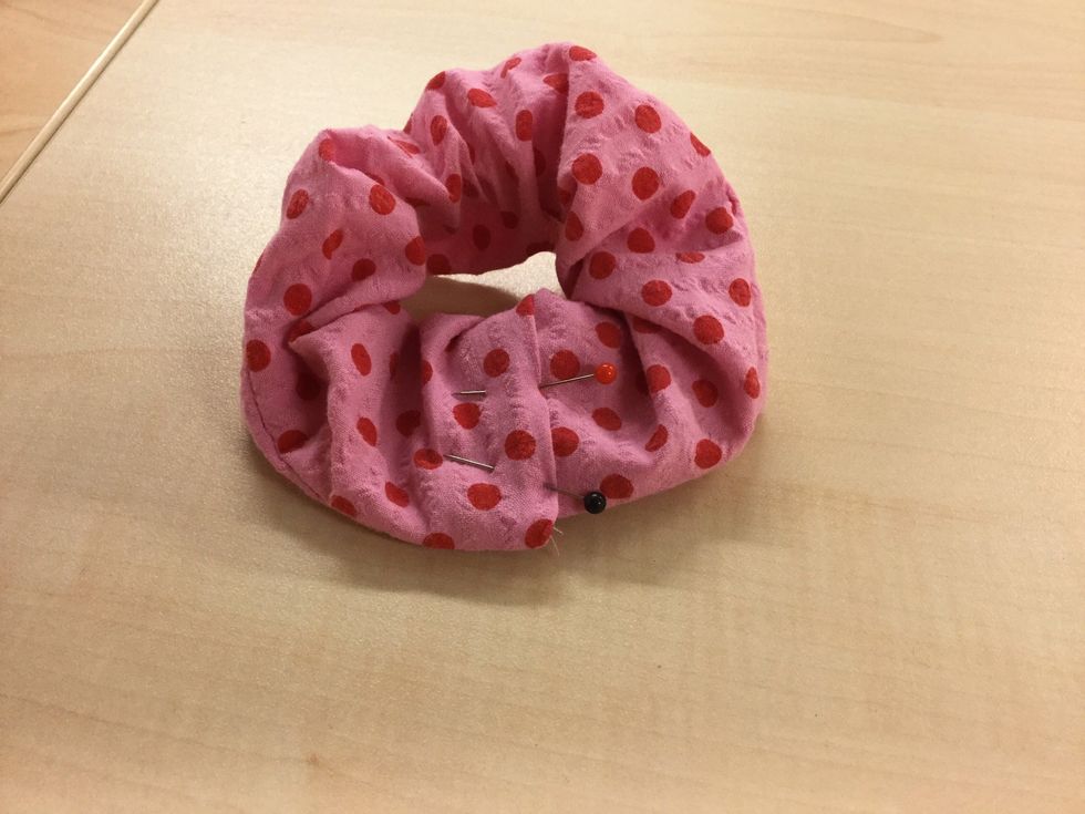 L\u00e4gg den ena \u00e4nden i den andra och vik in kanterna lite. Be fr\u00f6ken om hj\u00e4lp om det \u00e4r sv\u00e5rt. S\u00e4tt n\u00e5gra knappn\u00e5lar.