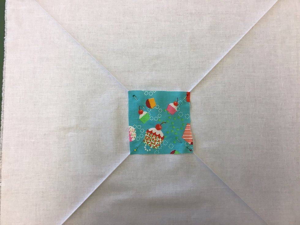 L\u00e4gg din f\u00f6rsta lapp (10x10 cm) med r\u00e4tsidan (den fina sidan) upp p\u00e5 mitten av det stora tyget (50x50 cm), ta hj\u00e4lp av dina pressade linjer p\u00e5 din stora tygbit f\u00f6r att f\u00e5 lappen centrerad. Tv\u00e4rn\u00e5la.