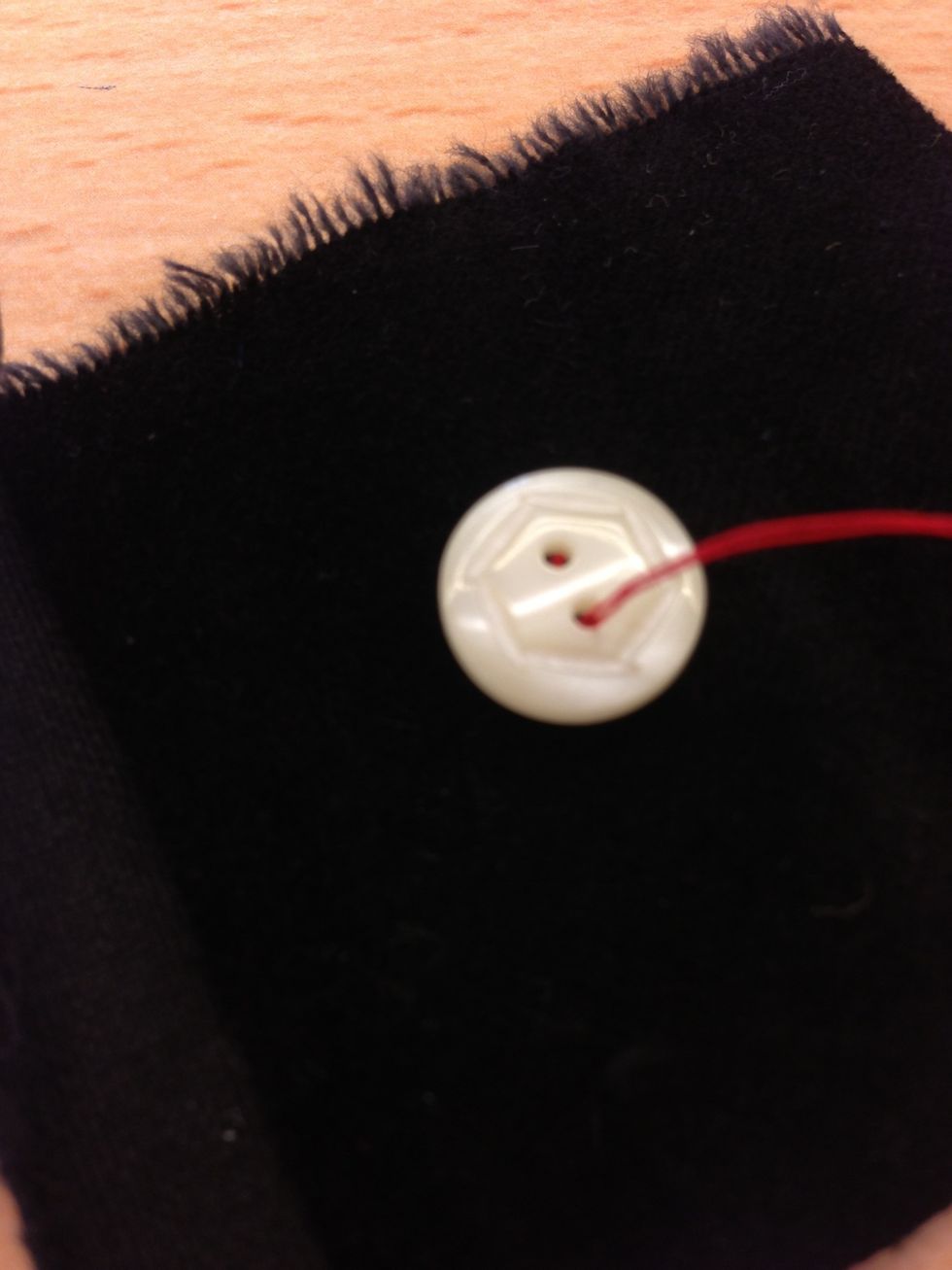 L\u00e4gg dit knappen och stick n\u00e5len genom ett av h\u00e5len.