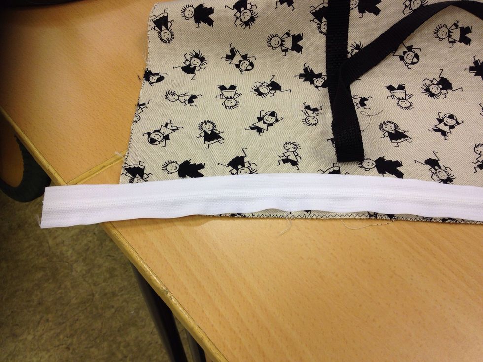 L\u00e4gg dragkedjan r\u00e4ta mot r\u00e4ta i \u00f6verkanten p\u00e5 ena sidan av v\u00e4skan.