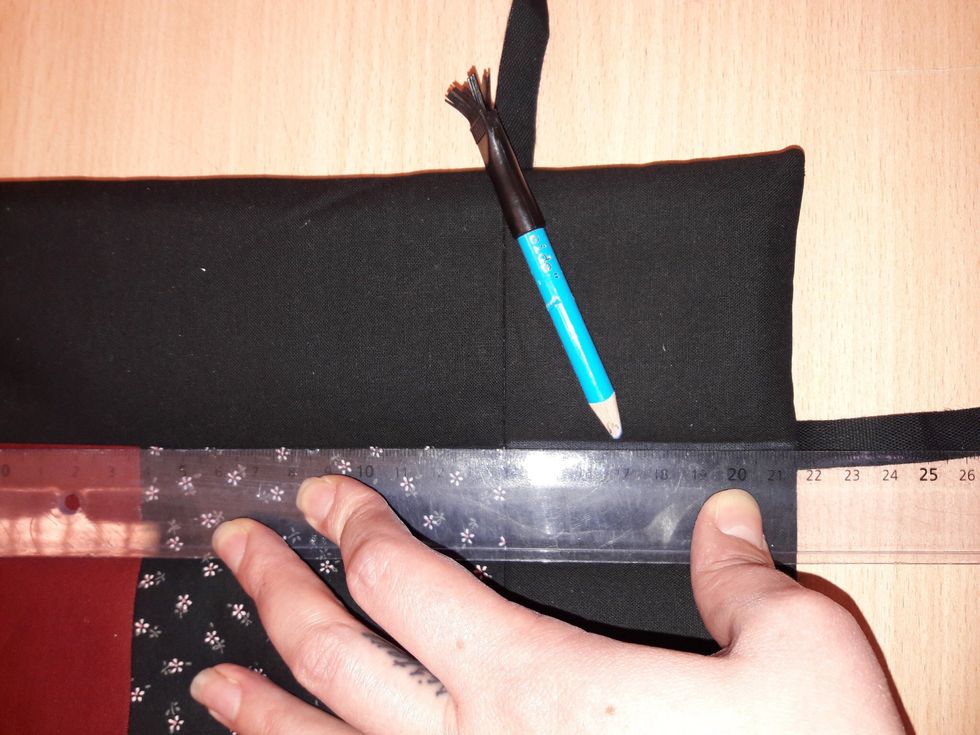 L\u00e4gg en linjal l\u00e4ngst med kanten p\u00e5 lapptekniksrutan och rita ett streck med tygpenna rakt ut p\u00e5 den sida d\u00e4r det inte redan finns en s\u00f6m.