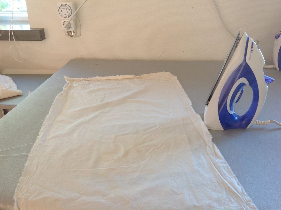 L\u00e4gg en skyddsduk \u00f6ver tyget och vlieselinet. Detta g\u00f6r du f\u00f6r att undvika att f\u00e5 lim p\u00e5 strykj\u00e4rnet.