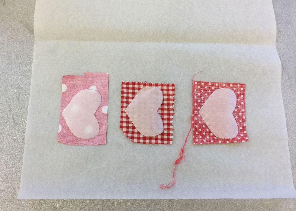 L\u00e4gg f\u00f6rst bakpl\u00e5tspapper, sen tygbitar med avigsidan upp. l\u00e4gg p\u00e5 vliesofixet med limmen ner mot tyget