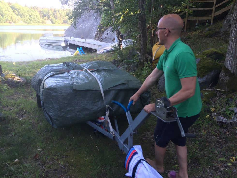 L\u00e4gg hela paketet ovanp\u00e5 trailern. Se till att du hittar dess mittpunkt. Dra tv\u00e5 sp\u00e4nnband runt b\u00e5ttrailern och paketet. Det ena 90 grader mot det andra.